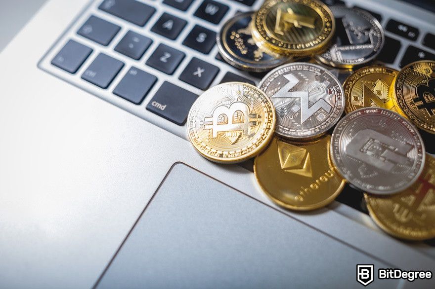 History of cryptocurrency: Stack of cryptocurrency coins laying on a laptop.