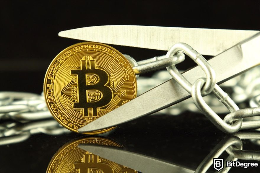 History of cryptocurrency: A Bitcoin coin with scissor and chain.