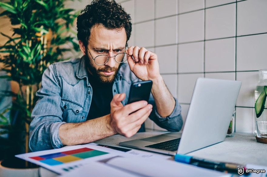 How do AI trading bots work: a man looks confused in front of his laptop.