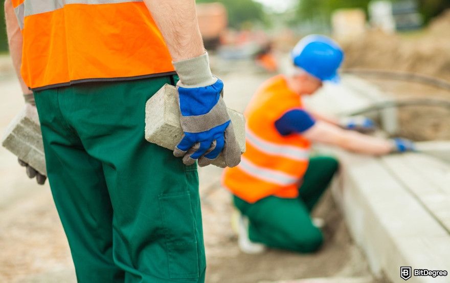How to build a crypto exchange: construction workers building a foundation.