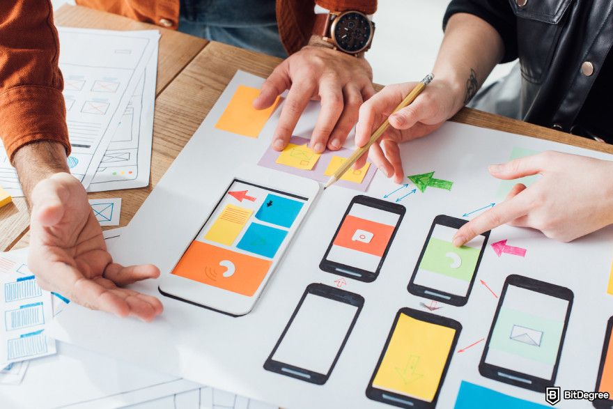 How to build a crypto exchange: a team of developers working on a wireframe.