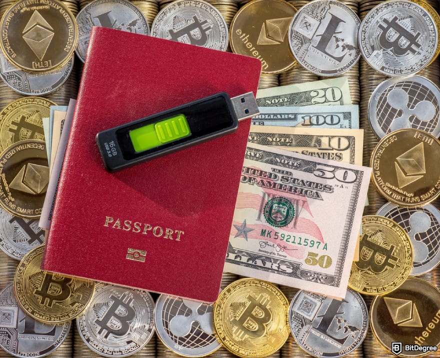 How to buy BTFD coin: a USB-shaped cold wallet on top of a passport and cryptocurrencies.