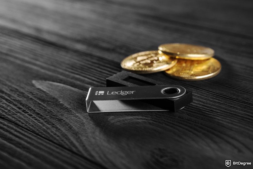 How to buy Movement coin: Ledger hardware wallet for cryptocurrency on a wood background.