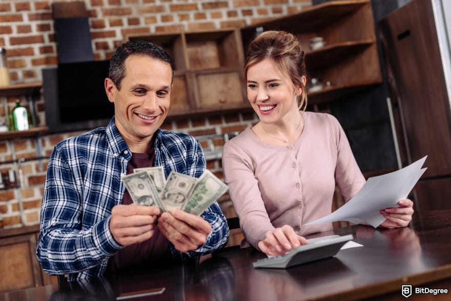 How to buy Qubetics crypto: a happy couple counting money together.