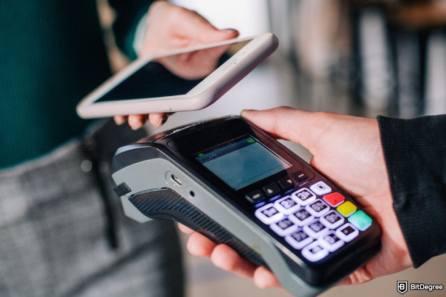 How to buy SUI: a person pay using smartphone for transaction.