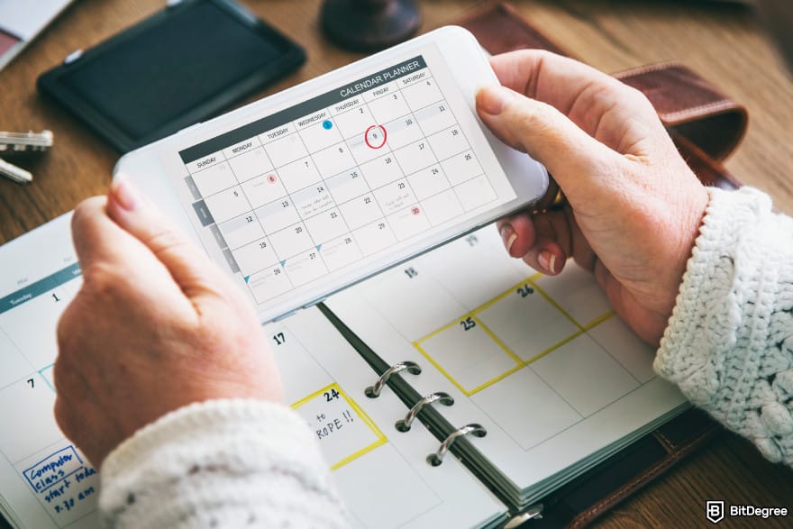 How to buy XYZVerse: a phone showing a calendar with a marked date.