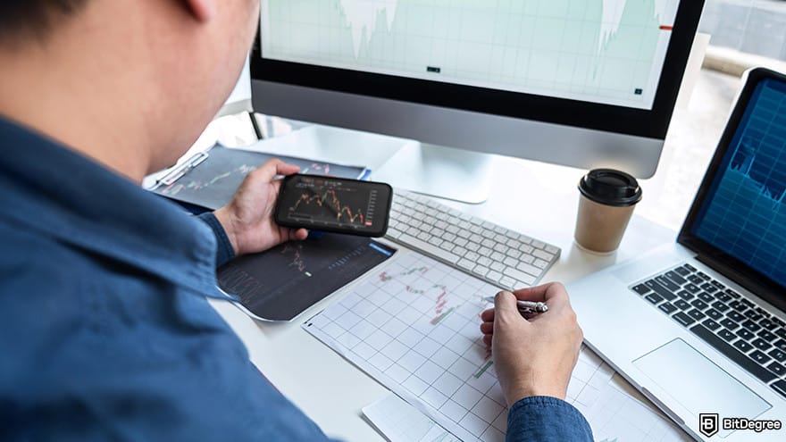How to cash out Bitcoin: A man looking at a trading screen on a smartphone and drawing.