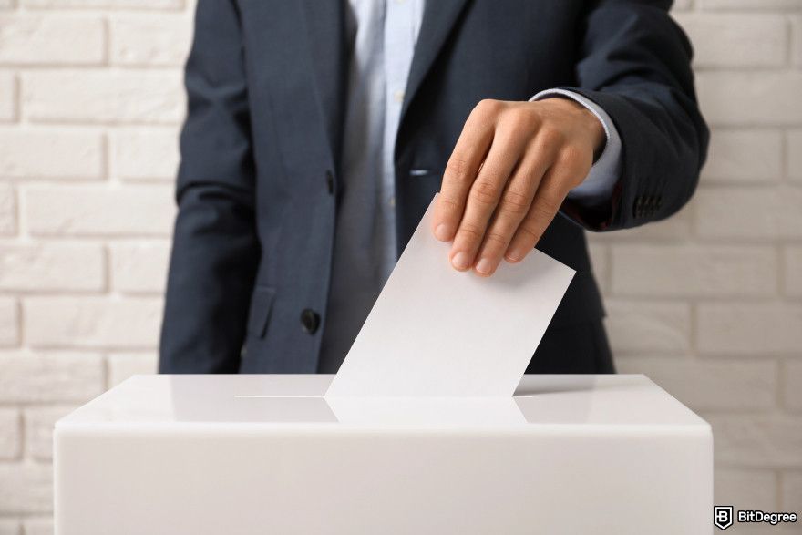 How to claim Dym airdrop: a man inserting a ballot as an illustration of voting.