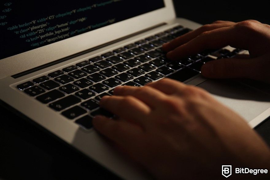 How to code for beginners: A person typing on a laptop in a dark setting.