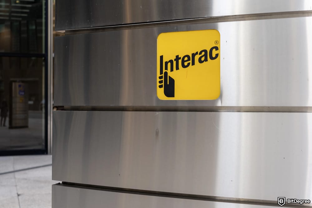 How to deposit money into crypto exchange: Interac logo on a wall. How to deposit money into crypto exchange: Interac logo on a wall.