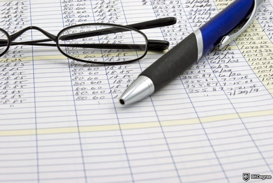 How to get into crypto: ledger calculations with glasses and pen.