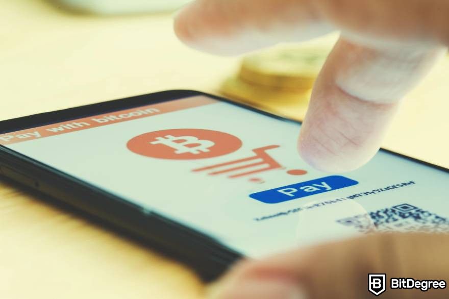 How to invest in Web3: A person uses smart phone to pay with Bitcoin