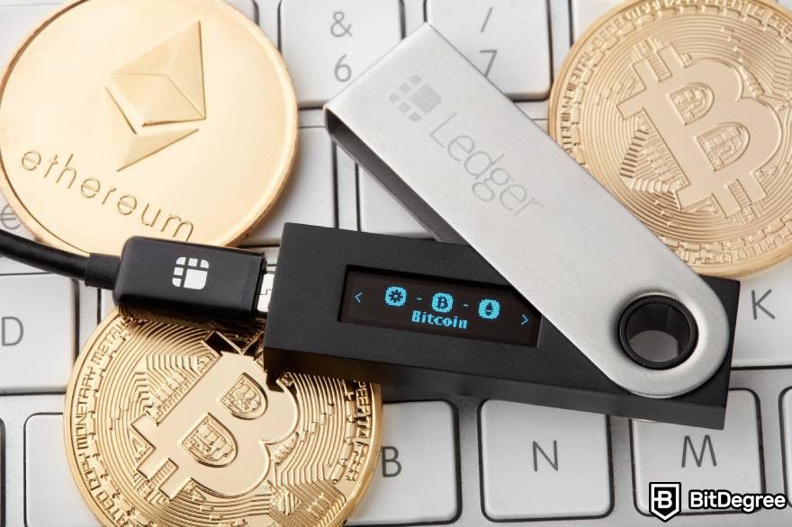 Cách đầu tư vào Web3: Hình ảnh ví cứng Ledger hiển thị đồng Bitcoin và Ether trên bàn phím