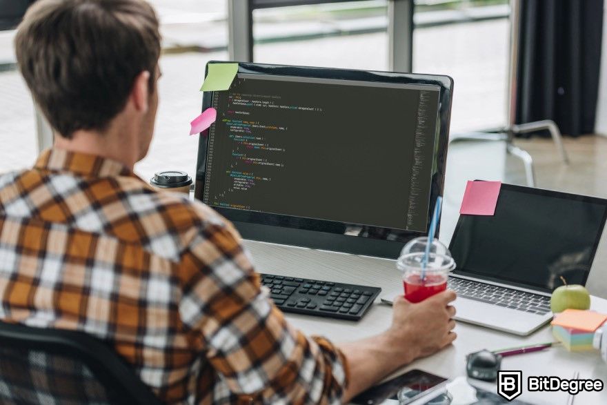 How to make a video game: A person looking at a code on a monitor.