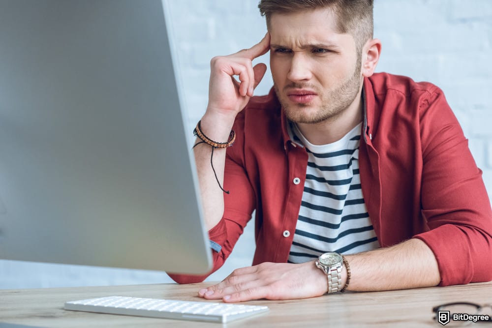 How to open a Coinbase Corporate account: a confused man looking at a computer.
