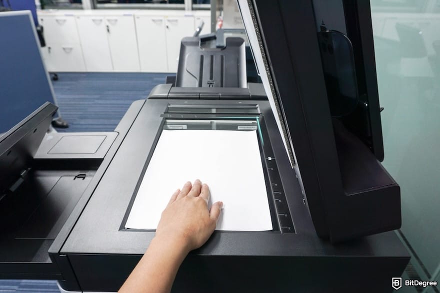 How to open a Coinbase Corporate account: a person scanning a paper using a printer.