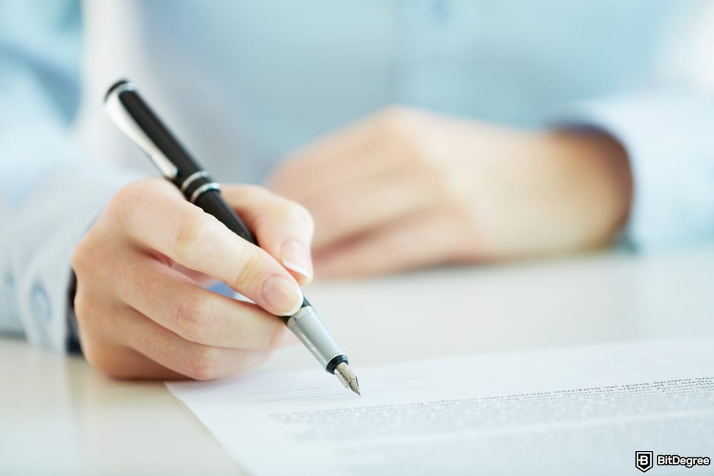 How to open a Coinbase Corporate account: a person signing a document.