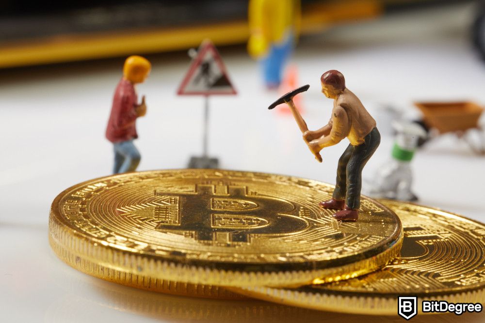 How to pay with Bitcoin: a close-up of two miner toys and Bitcoin.