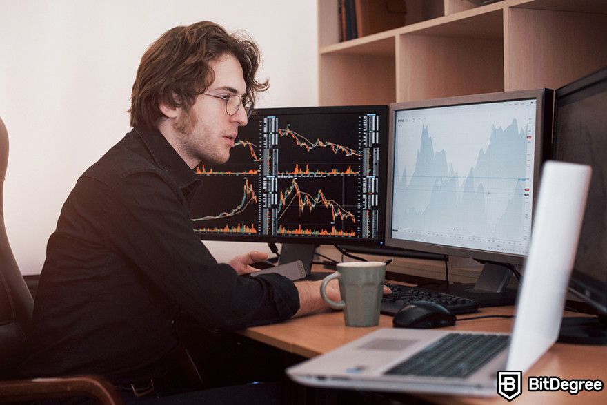 How to read candlesticks: Person with multiple screens reviewing price charts.