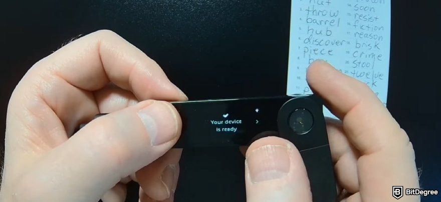How to recover Ledger: a pair of hands holding a Ledger wallet with the device ready message displayed.