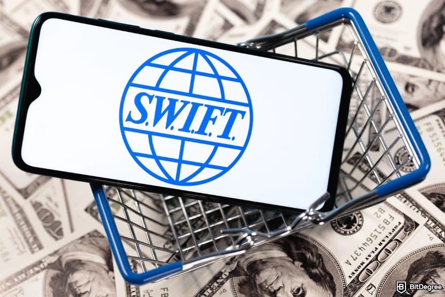 How to send money online: a phone in a mini shopping cart with the Swift logo on it.