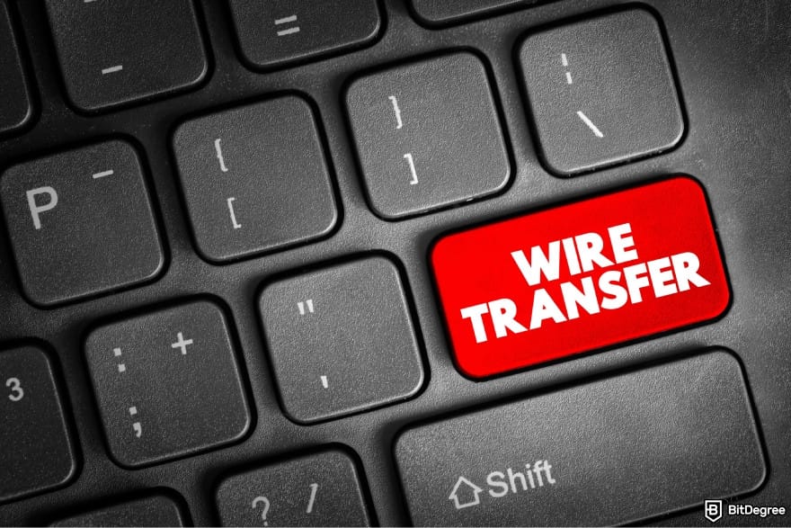 How to send money online: a keyboard with a red button that says WIRE TRANSFER.