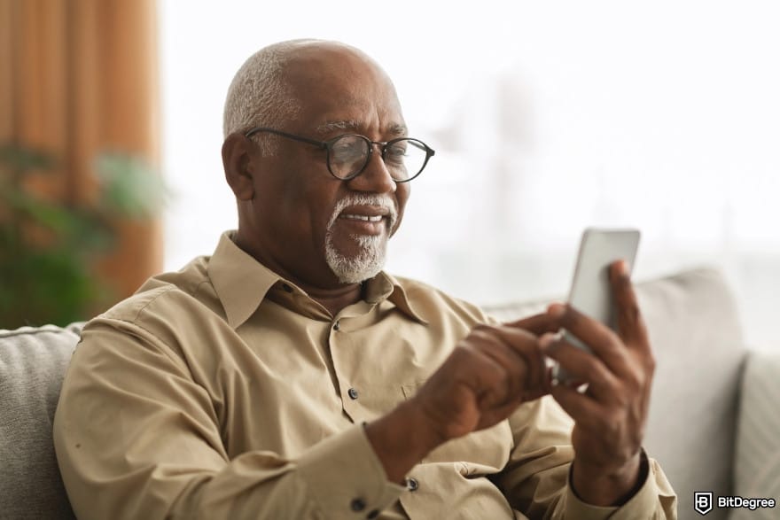 How to send money to Nigeria from USA: older gentleman using a smartphone.