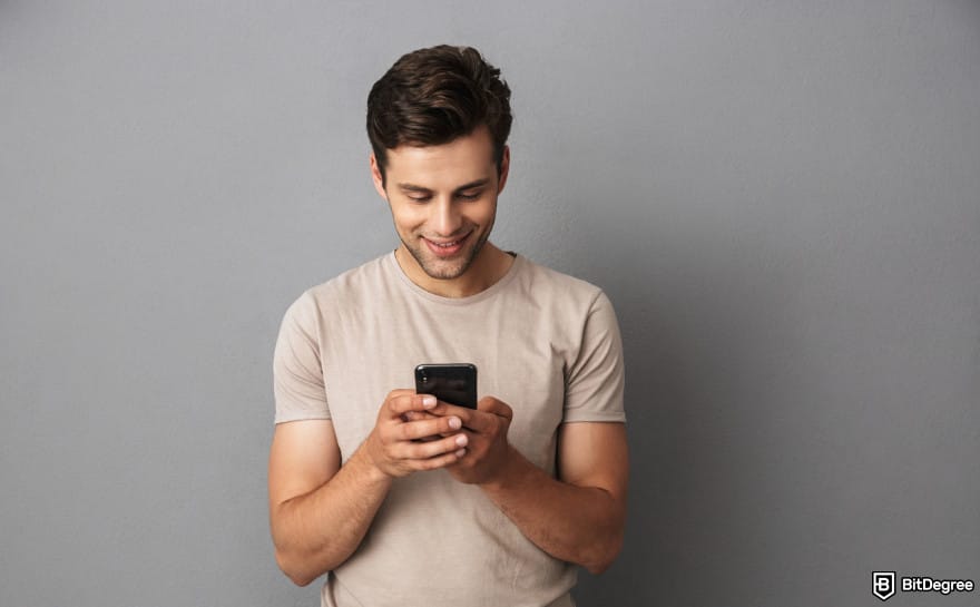 How to send money to someone without a bank account: man holding phone to illustrate adding funds.