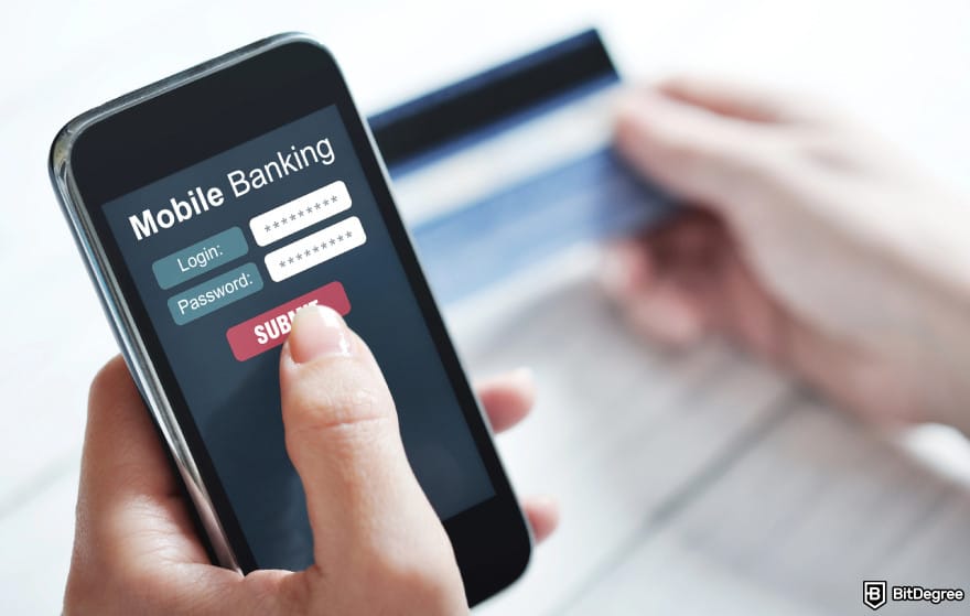 How to send money with debit card: person holding phone with mobile banking shown on screen.