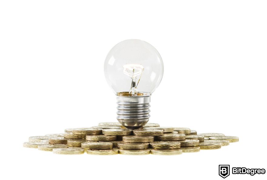 How to start a crypto business: a lightbulb lying on top of a pile of coins.