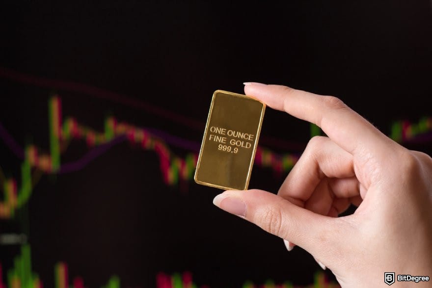 How to trade commodities: a hand holding a small gold bar.