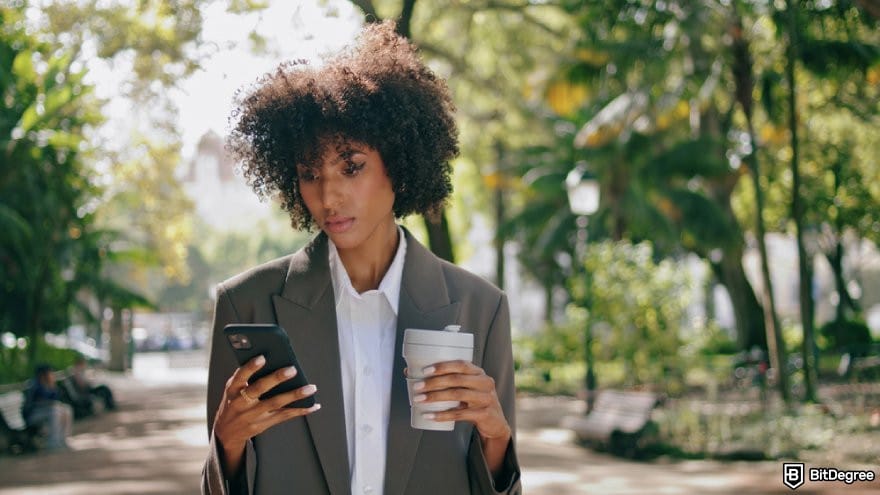 How to trade commodities: a person looking at their phone.