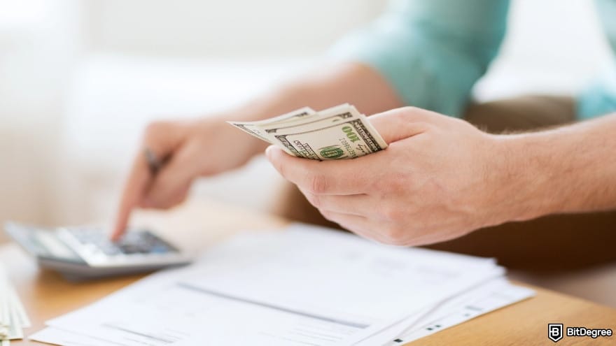 How to trade crypto futures: close up of a person counting money and making notes. How to trade crypto futures: close up of a person counting money and making notes.