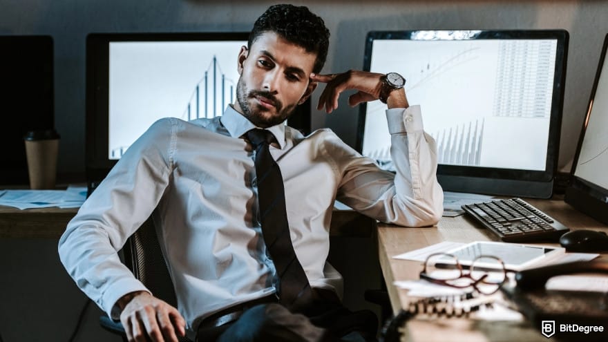 How to trade crypto futures: a trader sitting at table and looking away. How to trade crypto futures: a trader sitting at table and looking away.