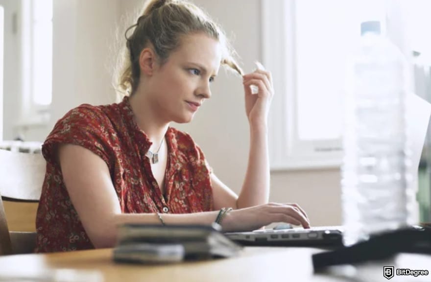 How to trade futures on Coinbase: a woman in thought while twirling her hair.