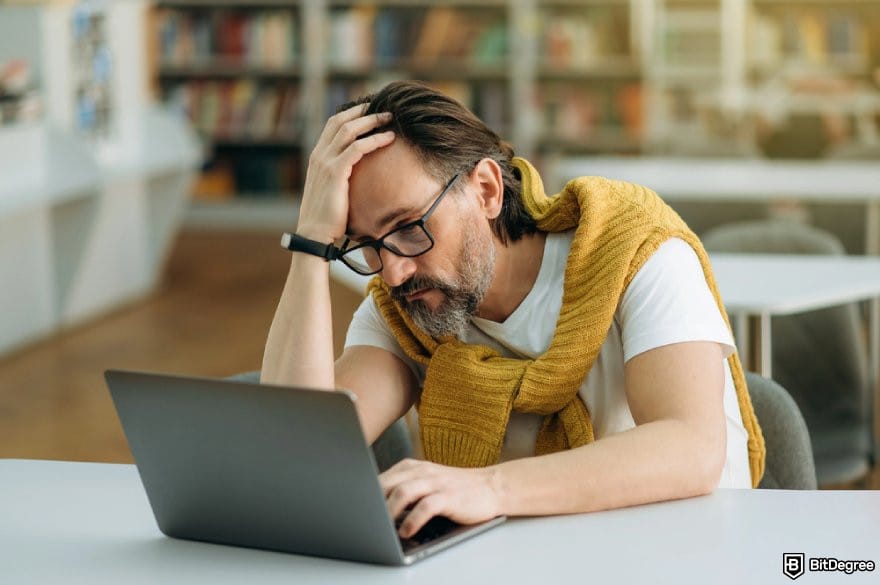 How to trade US stocks for beginners: a person looking at a laptop with a frustrated expression. How to trade US stocks for beginners: a person looking at a laptop with a frustrated expression.