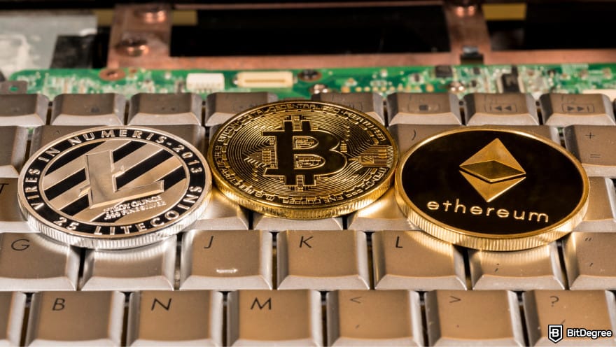 How to transfer crypto from Kraken: a Litecoin, a Bitcoin, and an Ethereum coin lying on top of a keyboard.