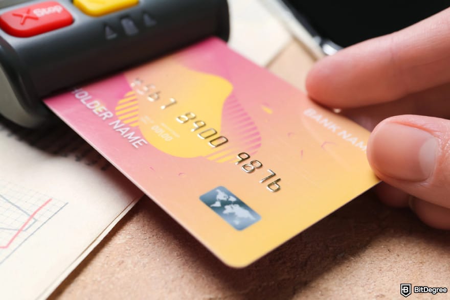 How to transfer money from Apple Pay to bank instantly: a hand inserting a debit card to a POS terminal.