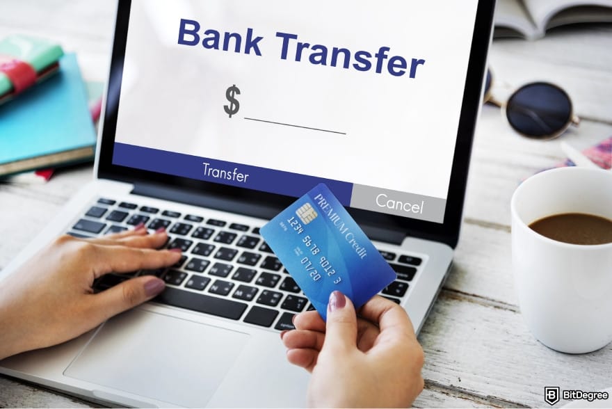 How to transfer money from bank account: a person holding a debit card.