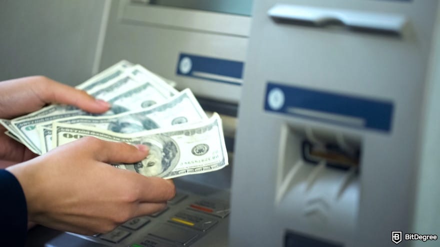 How to transfer money from Chime to bank account: hands holding money withdrawn from an ATM.