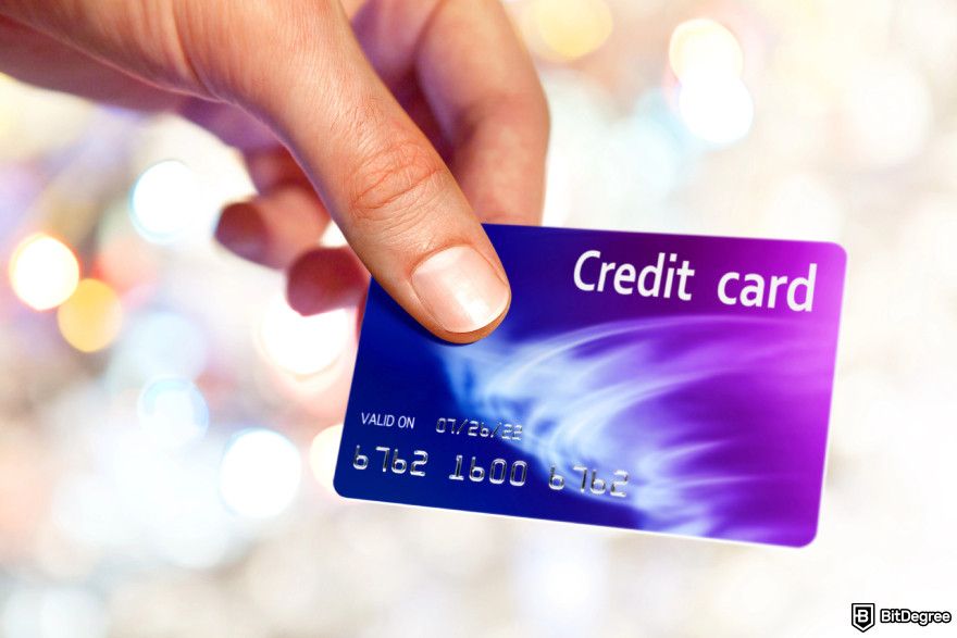 How to turn crypto into cash: a person holding a credit card.