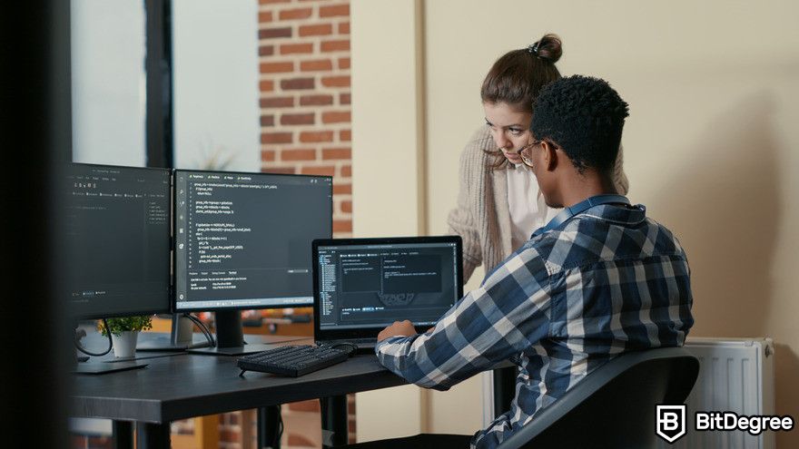 How to use GitHub Copilot: Two people working on coding project.