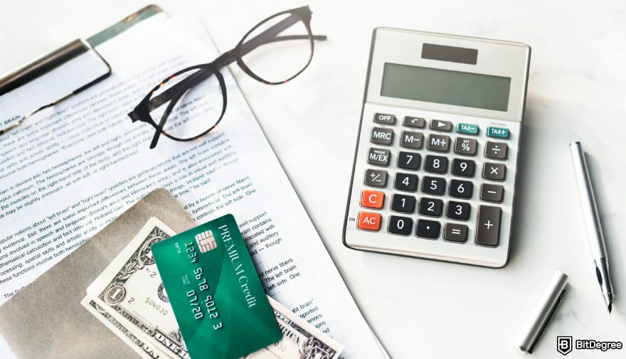 How to withdraw cash from credit card: credit card, money, glasses, a calculator, and a pen on a desk.