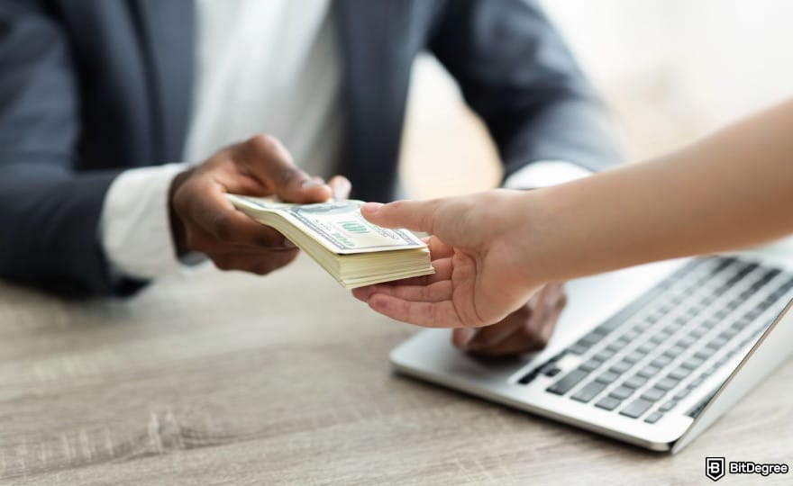 How to withdraw cash from Credit Card: a man handing a stack of cash to another person.