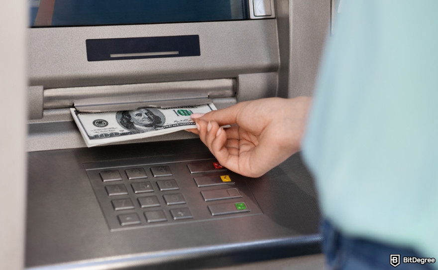 How to withdraw crypto from Uphold: a woman withdrawing money from an ATM.