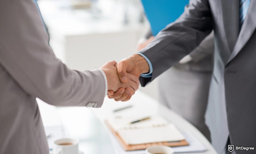 How to withdraw from KuCoin in India: two people shaking hands to illustrate peer-to-peer transaction.