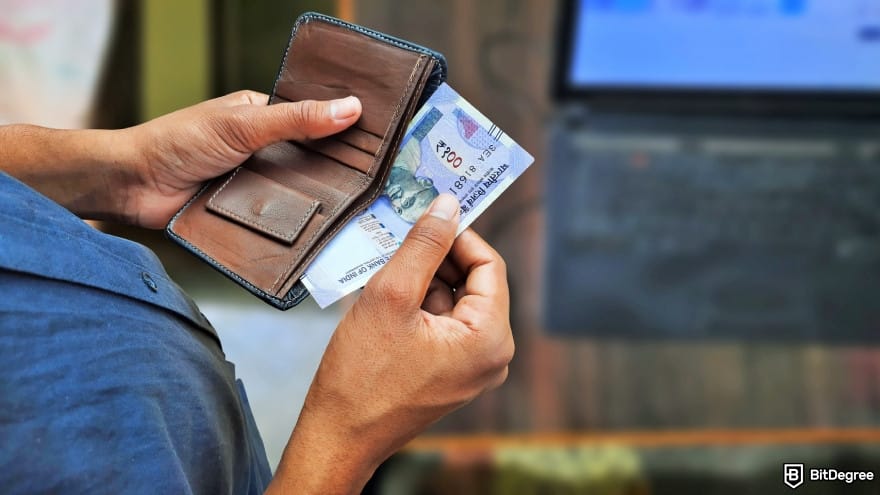 How to withdraw money from Binance in India: a person taking Indian banknotes out from wallet.