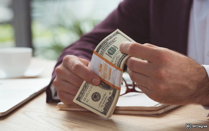 How to withdraw money from checking account: a man holding USD bills. How to withdraw money from checking account: a man holding USD bills.