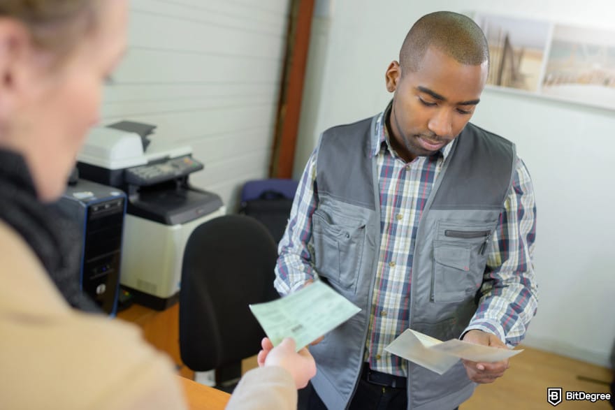 How to withdraw money from KuCoin: a man verifying documents of another person.