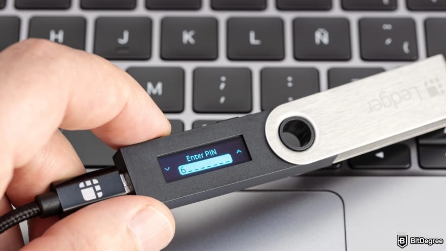 How to withdraw money from OKX in India: a person holding a Ledger hardware wallet on laptop. How to withdraw money from OKX in India: a person holding a Ledger hardware wallet on laptop.